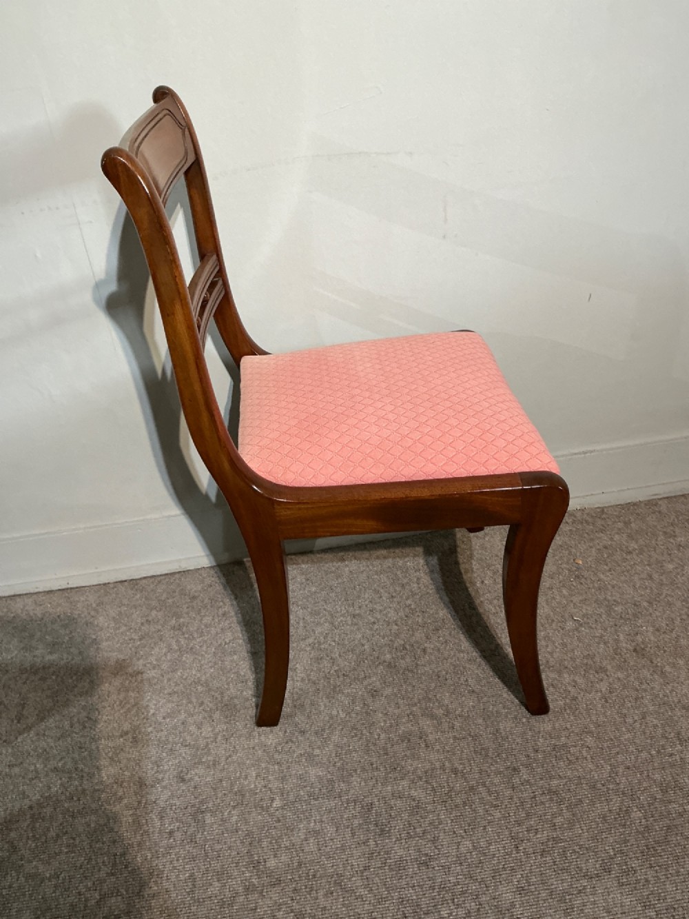 A set of six Regency mahogany dining chairs featuring tablet top rails, beaded crossbars, and rose-pink upholstered drop-in seats. View VII