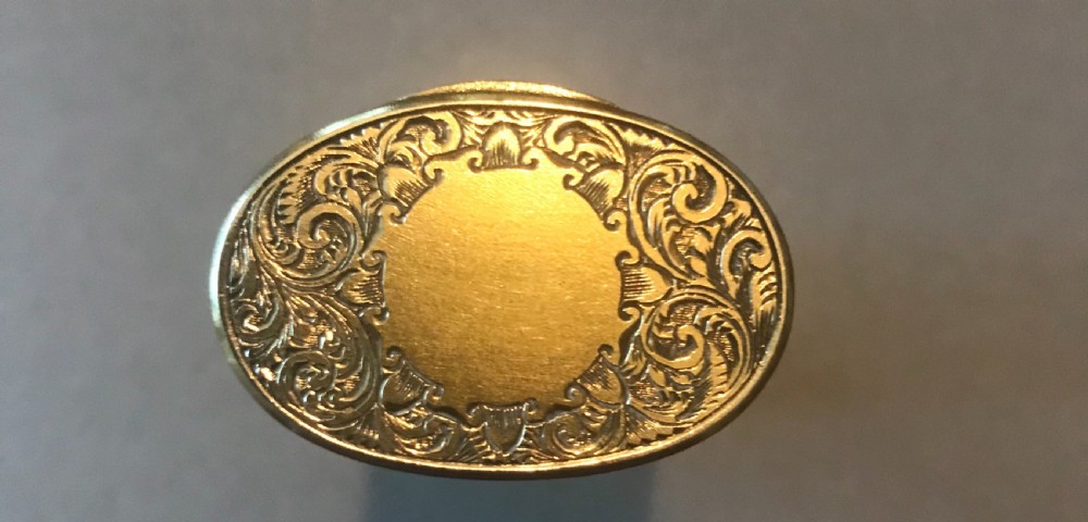 A 19th-century cylindrical cut glass scent bottle with detailed foliate scroll engraved gold-coloured metal mounts at the cap and base. View III