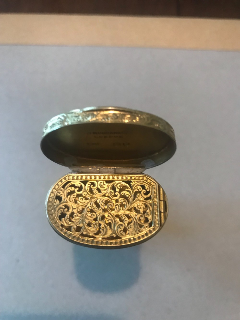 A 19th-century cylindrical cut glass scent bottle with detailed foliate scroll engraved gold-coloured metal mounts at the cap and base. View IV