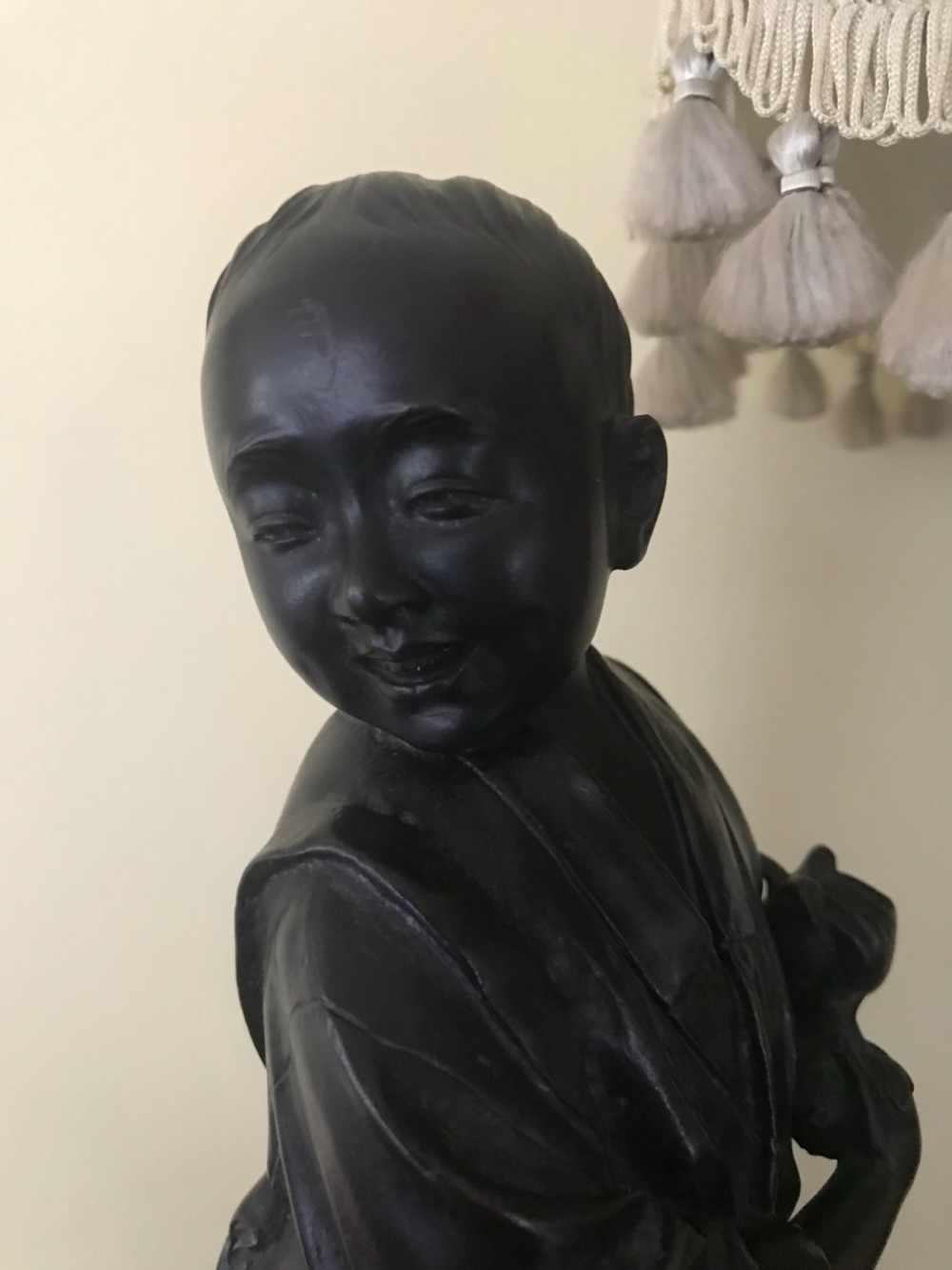 A dark bronze Japanese okimono sculpture depicting a boy in traditional kimono and geta sandals walking beside a chicken on a cast naturalistic base. View II
