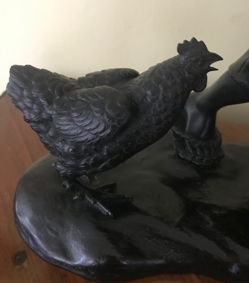A dark bronze Japanese okimono sculpture depicting a boy in traditional kimono and geta sandals walking beside a chicken on a cast naturalistic base. View IV