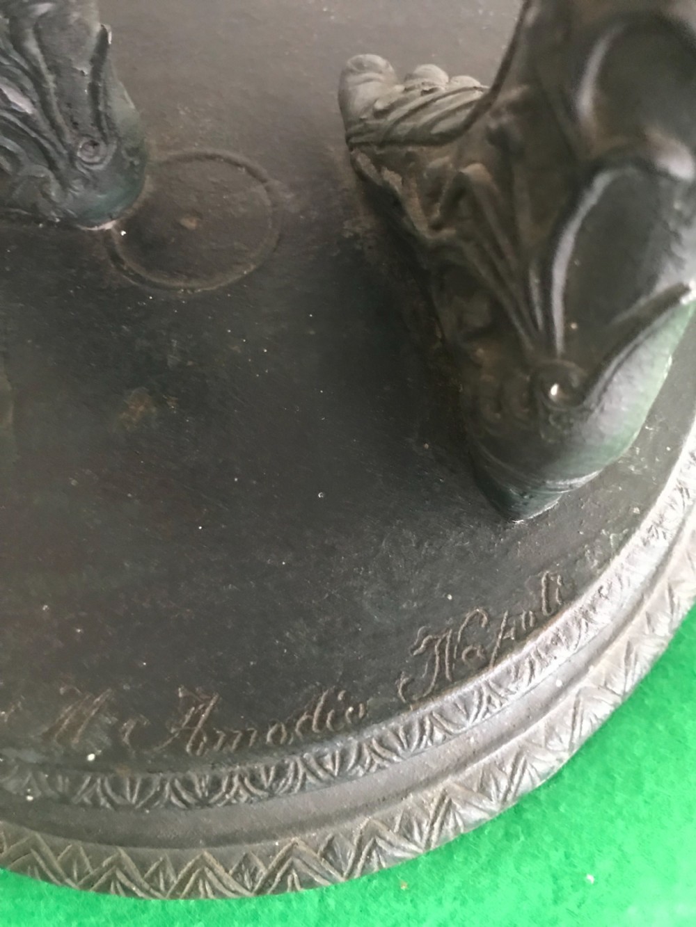 A dark patinated bronze sculpture depicting a standing nude male figure on a round stepped base. View III