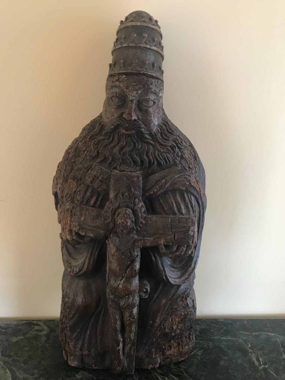 A 15th-century hand-carved oak sculpture depicting a bearded figure wearing a papal tiara and holding a crucifix.