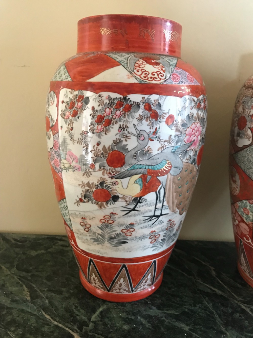 A pair of Japanese Kutani porcelain baluster vases painted with figurative scenes, fishbowls, and geometric borders in iron-red and gold. View II