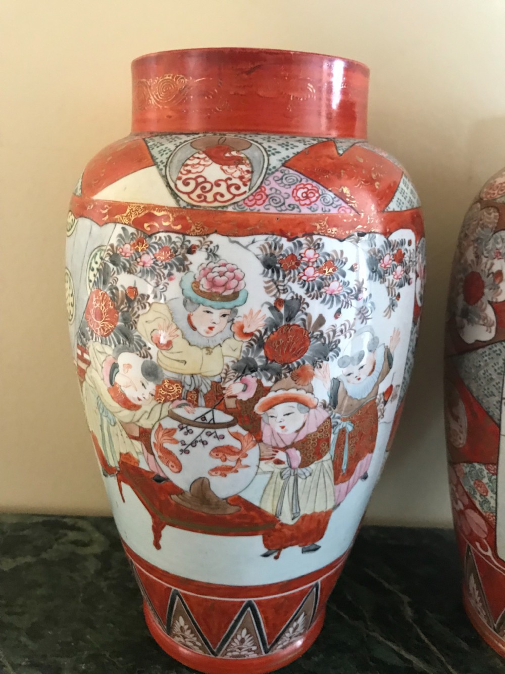 A pair of Japanese Kutani porcelain baluster vases painted with figurative scenes, fishbowls, and geometric borders in iron-red and gold. View IV