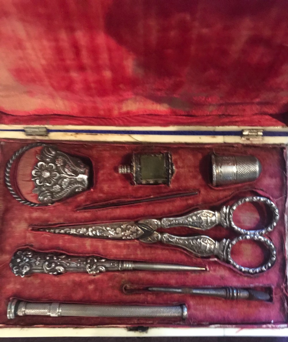 An open Victorian tortoiseshell rectangular sewing box featuring a crimson red velvet fitted interior with intricate silver tools including scissors and a thimble. View IV