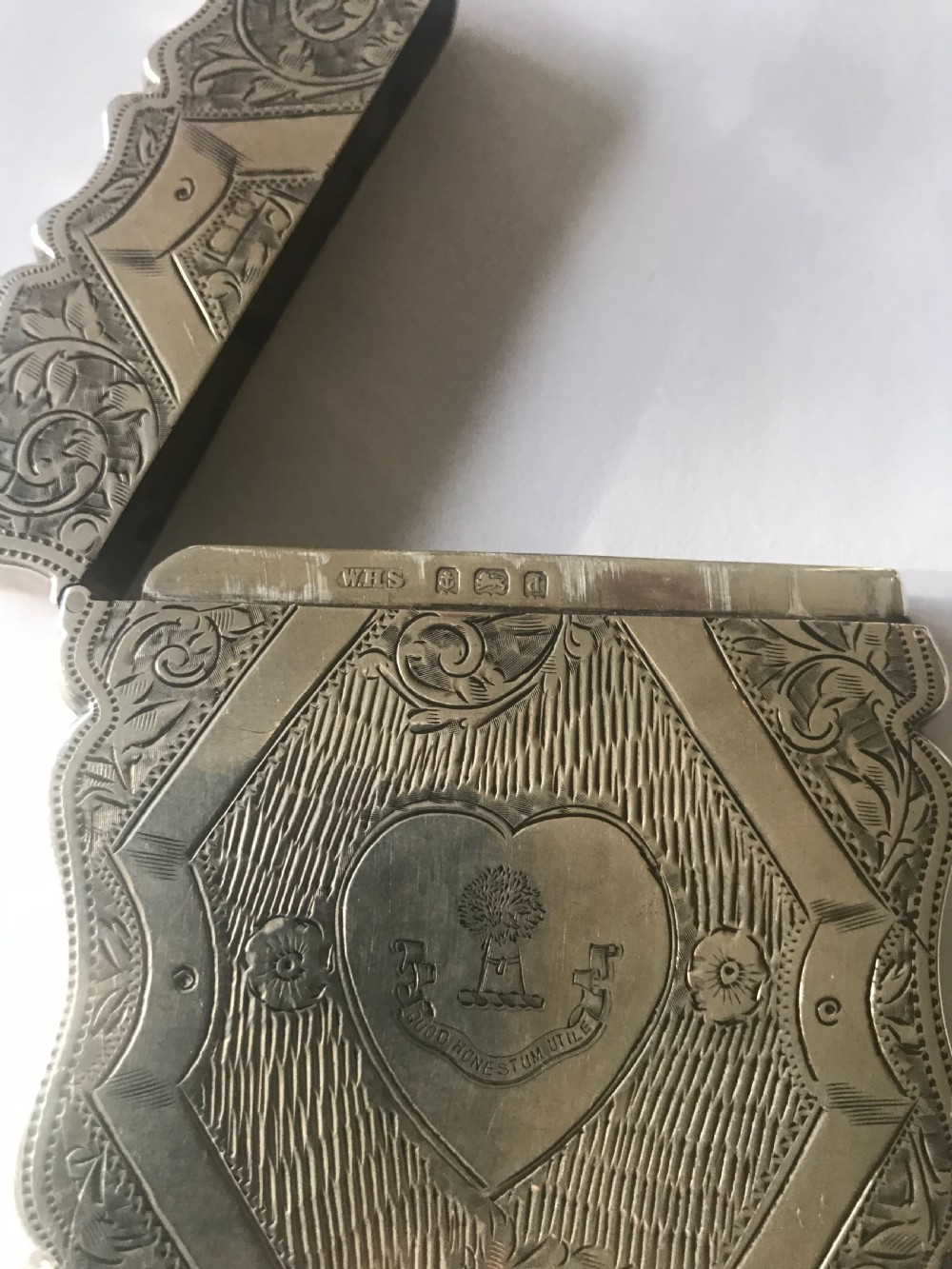 A rectangular Victorian sterling silver calling card case featuring floral engraving and engine-turned decoration with wavy edges. View II