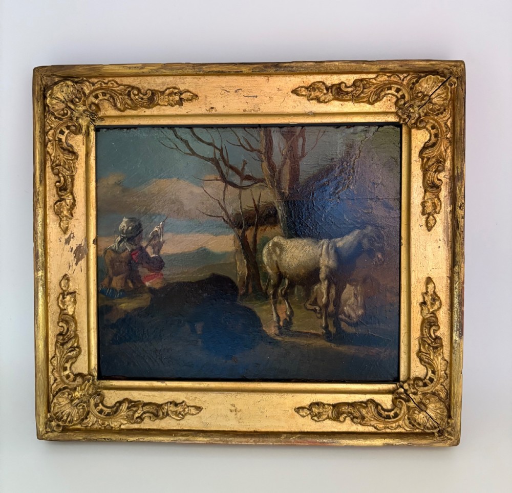 An eighteenth-century style pastoral oil painting on an oak panel featuring a shepherd and farm animals set within a carved giltwood frame.