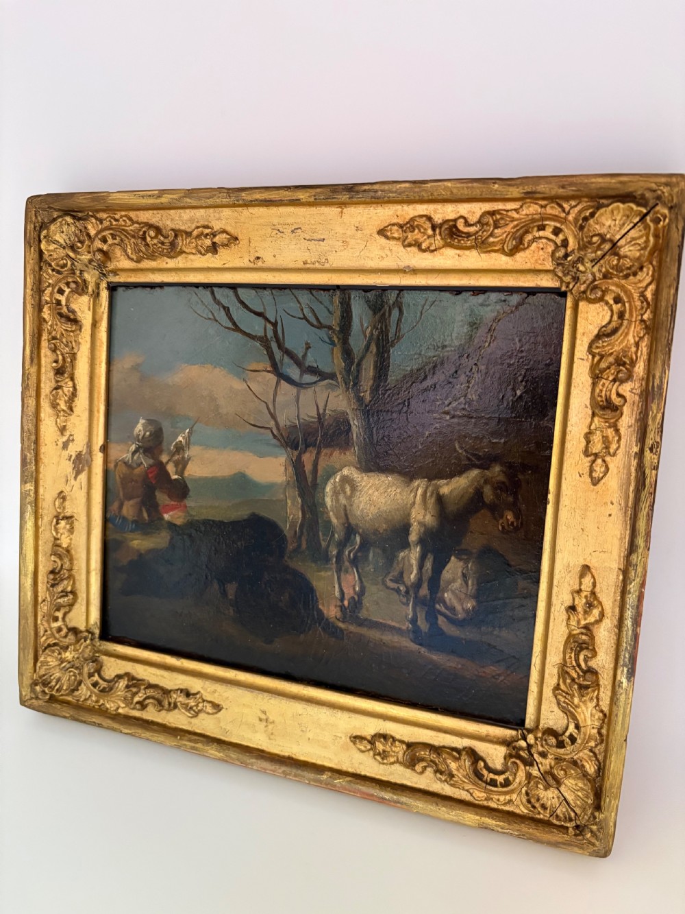 An eighteenth-century style pastoral oil painting on an oak panel featuring a shepherd and farm animals set within a carved giltwood frame. View II