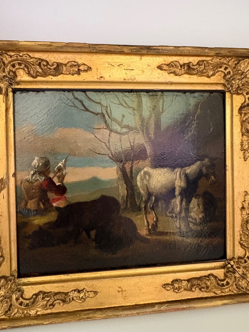 An eighteenth-century style pastoral oil painting on an oak panel featuring a shepherd and farm animals set within a carved giltwood frame. View IV
