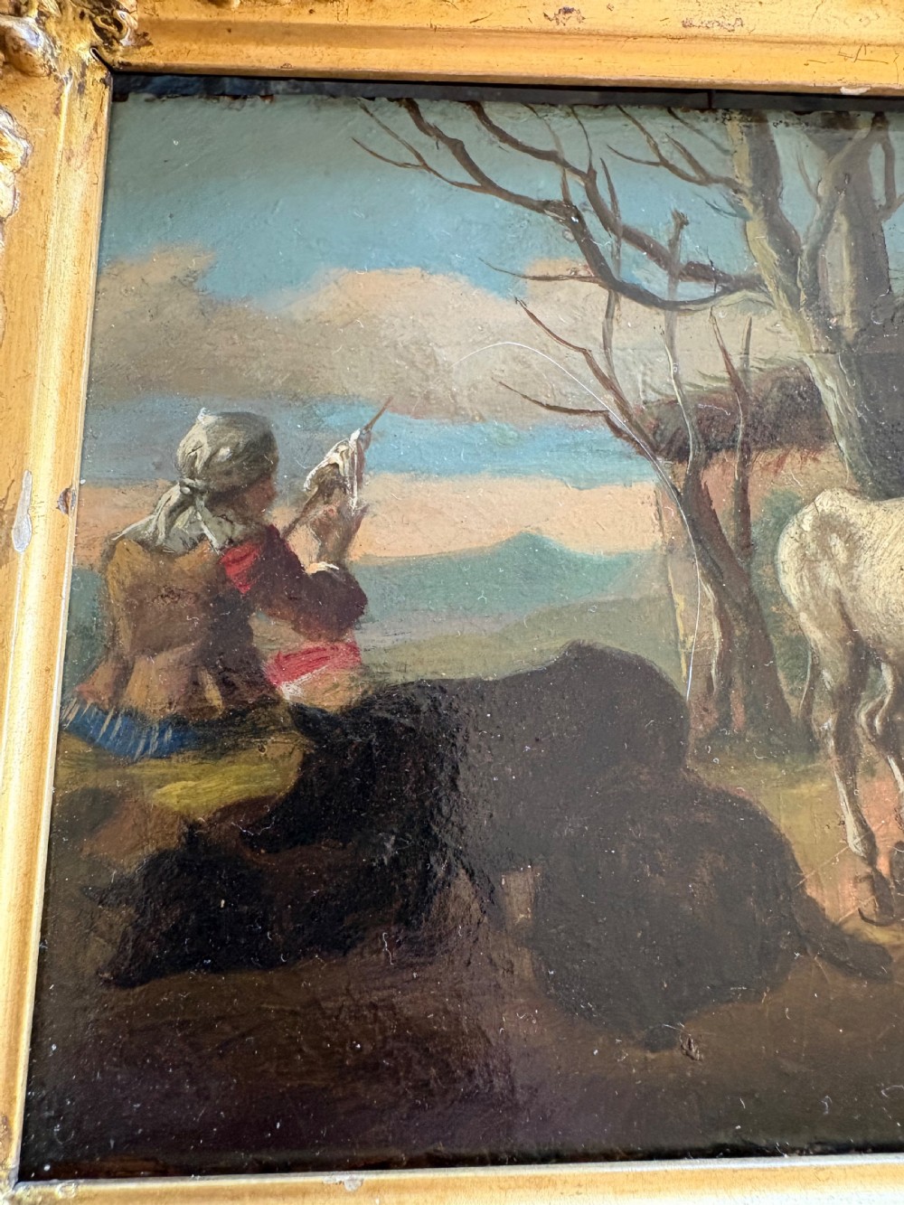 An eighteenth-century style pastoral oil painting on an oak panel featuring a shepherd and farm animals set within a carved giltwood frame. View V