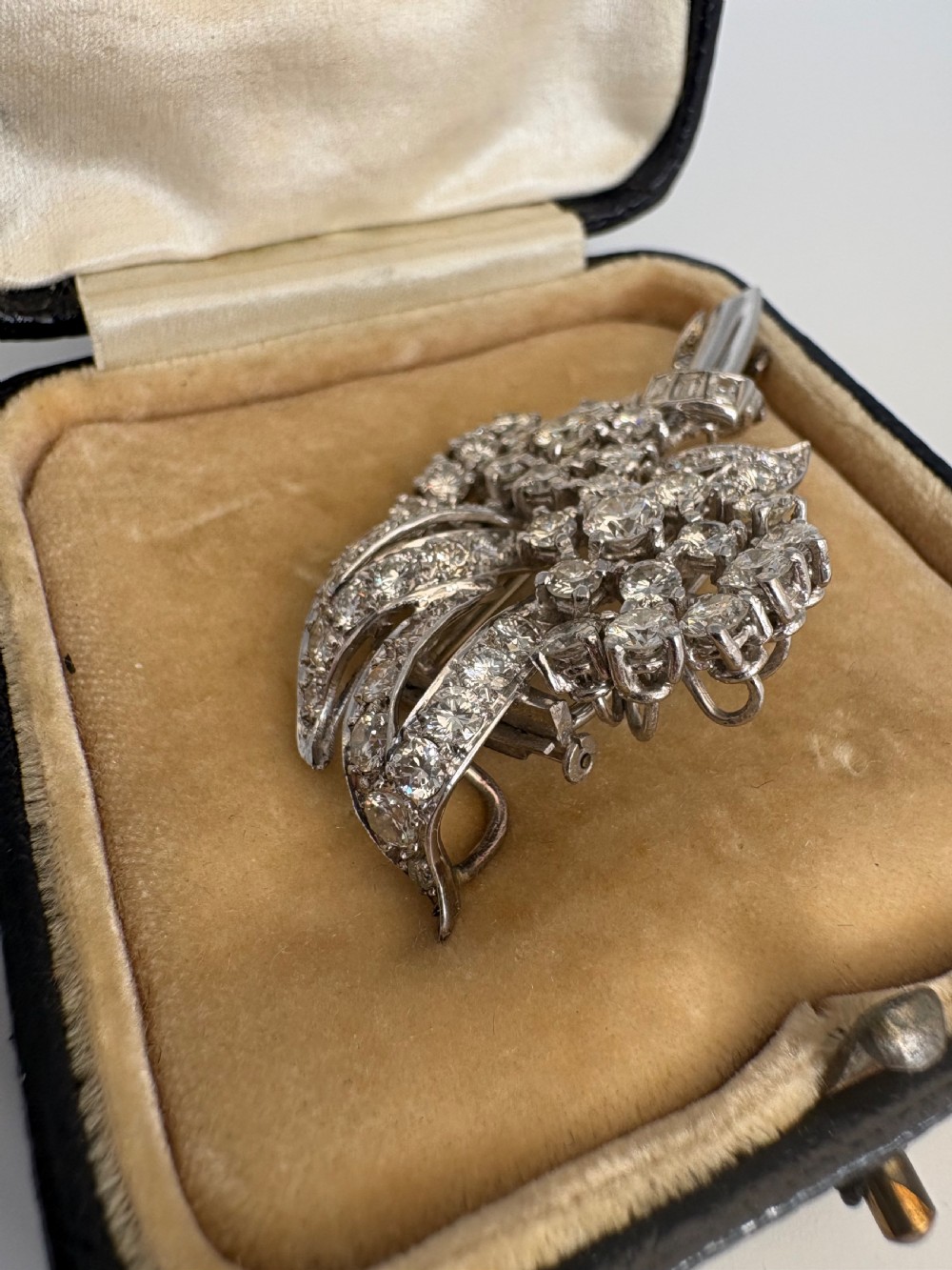 A 1930s platinum spray brooch densely set with round brilliant and baguette-cut diamonds arranged in stylized ribbon loops. View III