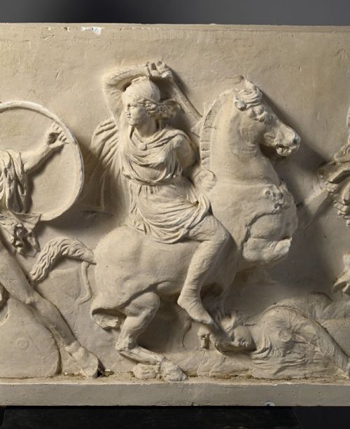 fig 3. A horizontal cream plaster bas-relief panel depicting a classical battle scene between cavalry warriors and shield-bearing soldiers.