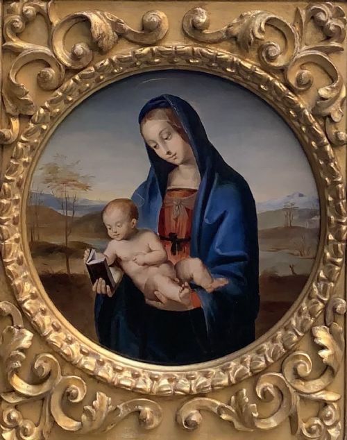 fig 1. A circular oil painting depicting the Virgin Mary in a blue cloak holding the Christ Child, enclosed within an ornate rectangular carved giltwood frame.