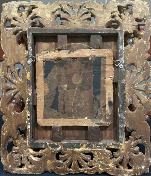 fig 2. A circular oil painting depicting the Virgin Mary in a blue cloak holding the Christ Child, enclosed within an ornate rectangular carved giltwood frame.