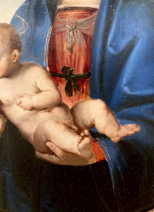 fig 5. A circular oil painting depicting the Virgin Mary in a blue cloak holding the Christ Child, enclosed within an ornate rectangular carved giltwood frame.
