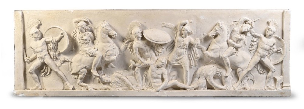 A horizontal cream plaster bas-relief panel depicting a classical battle scene between cavalry warriors and shield-bearing soldiers.