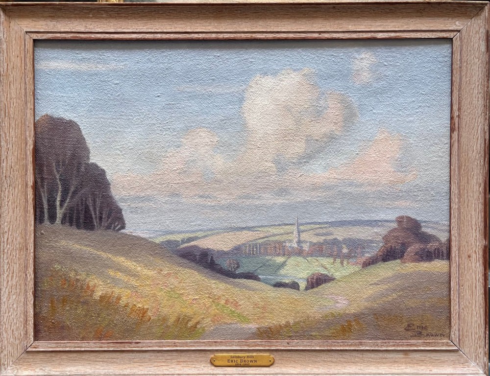 An oil painting depicting rolling countryside hills with a cathedral spire in the distance under a pale blue sky, signed by Eric Brown. View II