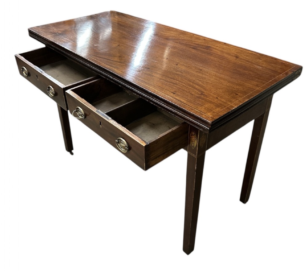A Georgian dark mahogany side table featuring two open drawers with brass ring handles, boxwood stringing inlay, and square tapered legs.