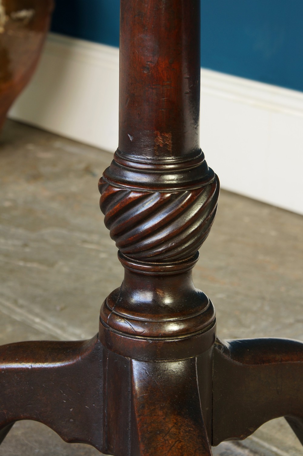 An 18th century dark mahogany tripod table with a circular dished top set on a turned column with cabriole legs and pad feet. View VI