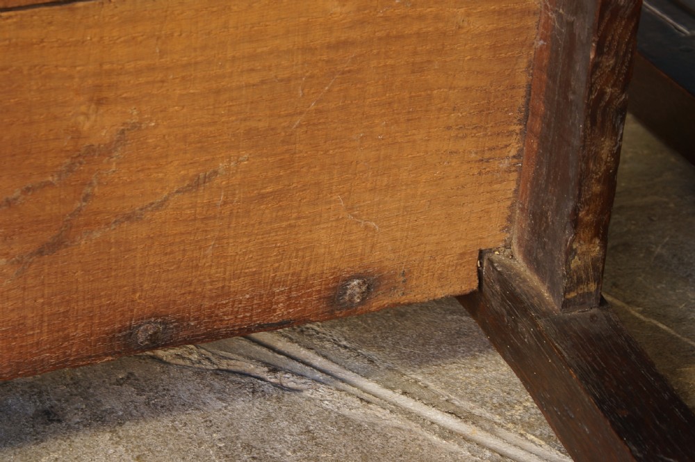 A pair of 17th-century dark oak Lancashire backstool chairs with panelled backs, shaped cresting rails, and turned front legs. View XI
