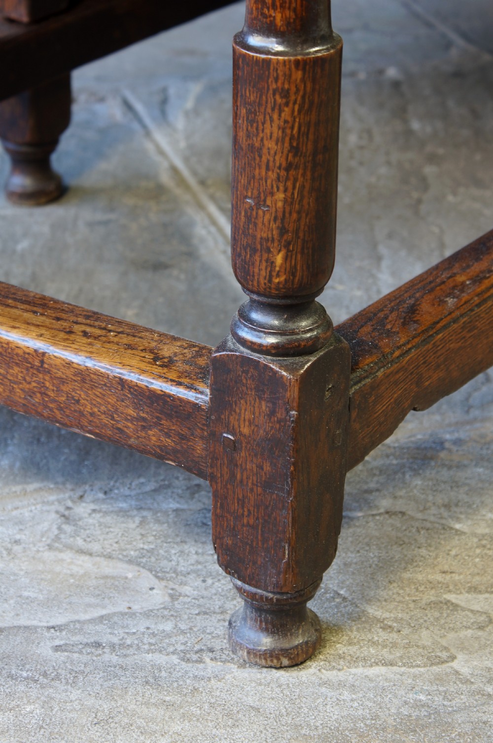 A large 18th-century dark oak gateleg dining table with a circular drop-leaf top supported by turned legs and stretchers. View XVII