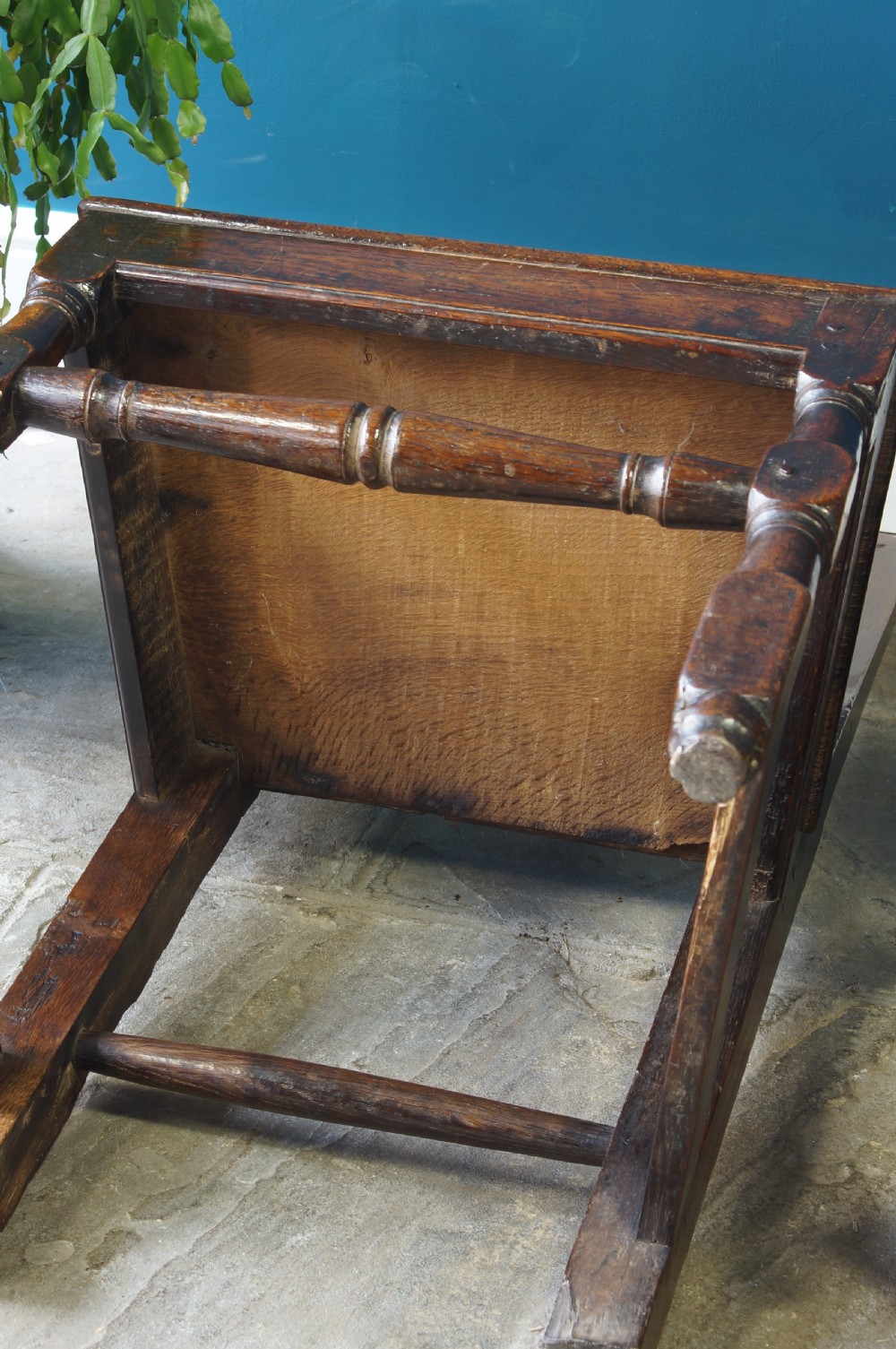 A pair of early 18th-century dark oak dining chairs with vase-shaped back splats, solid wooden seats, and turned front legs. View VII