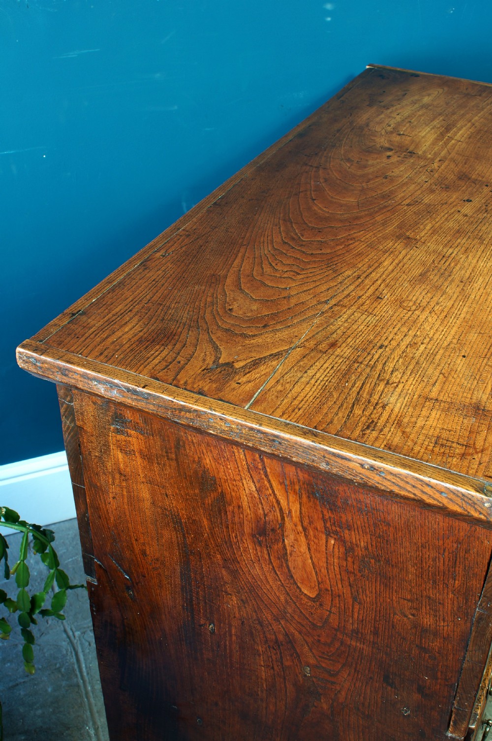 A Georgian elm mule chest featuring a hinged top lid over two wide drawers with brass swan-neck handles. View X