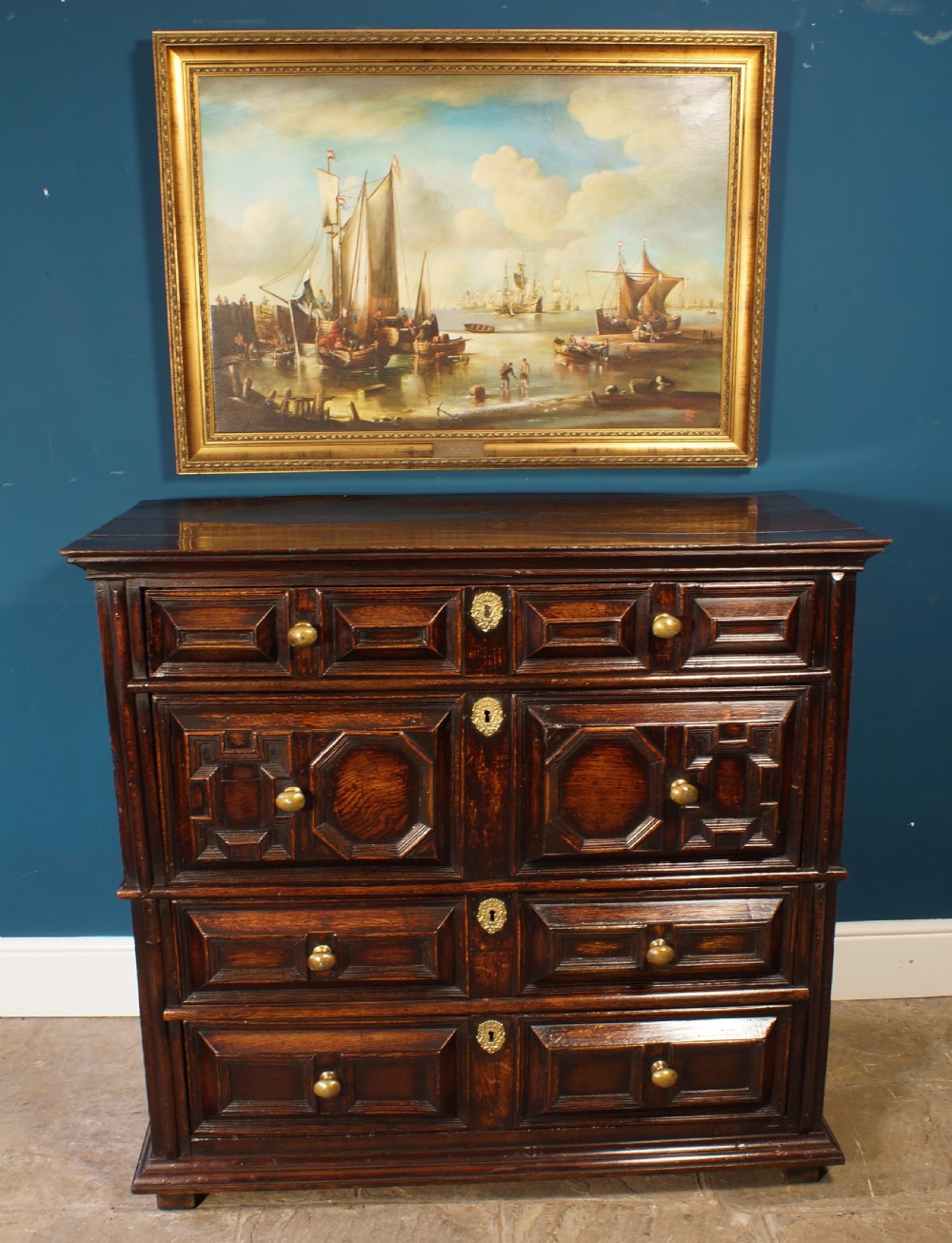 A dark oak 17th-century chest of drawers featuring geometric moulded drawer fronts and brass keyhole escutcheons. View III