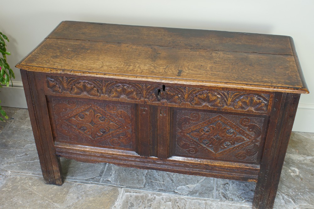 A small 17th-century dark oak coffer featuring hand-carved diamond panels, a decorative top frieze, and pegged joinery. View XI