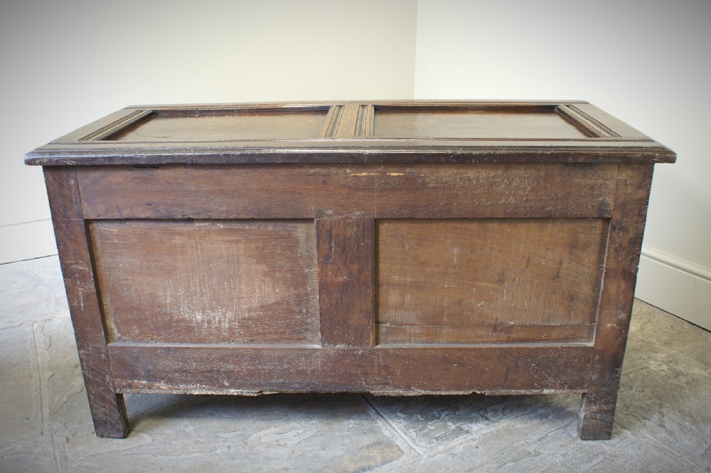 A 17th-century dark oak coffer featuring two carved front panels with geometric rosettes, an arcaded top rail, and an iron lockplate. View VIII