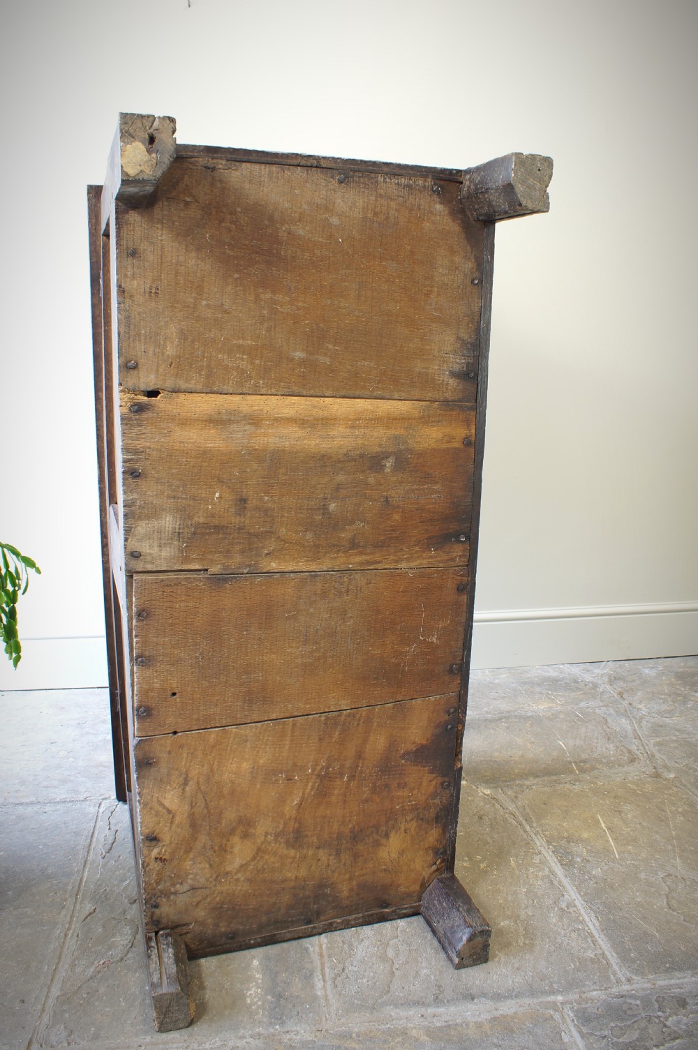 A 17th-century dark oak coffer featuring two carved front panels with geometric rosettes, an arcaded top rail, and an iron lockplate. View X