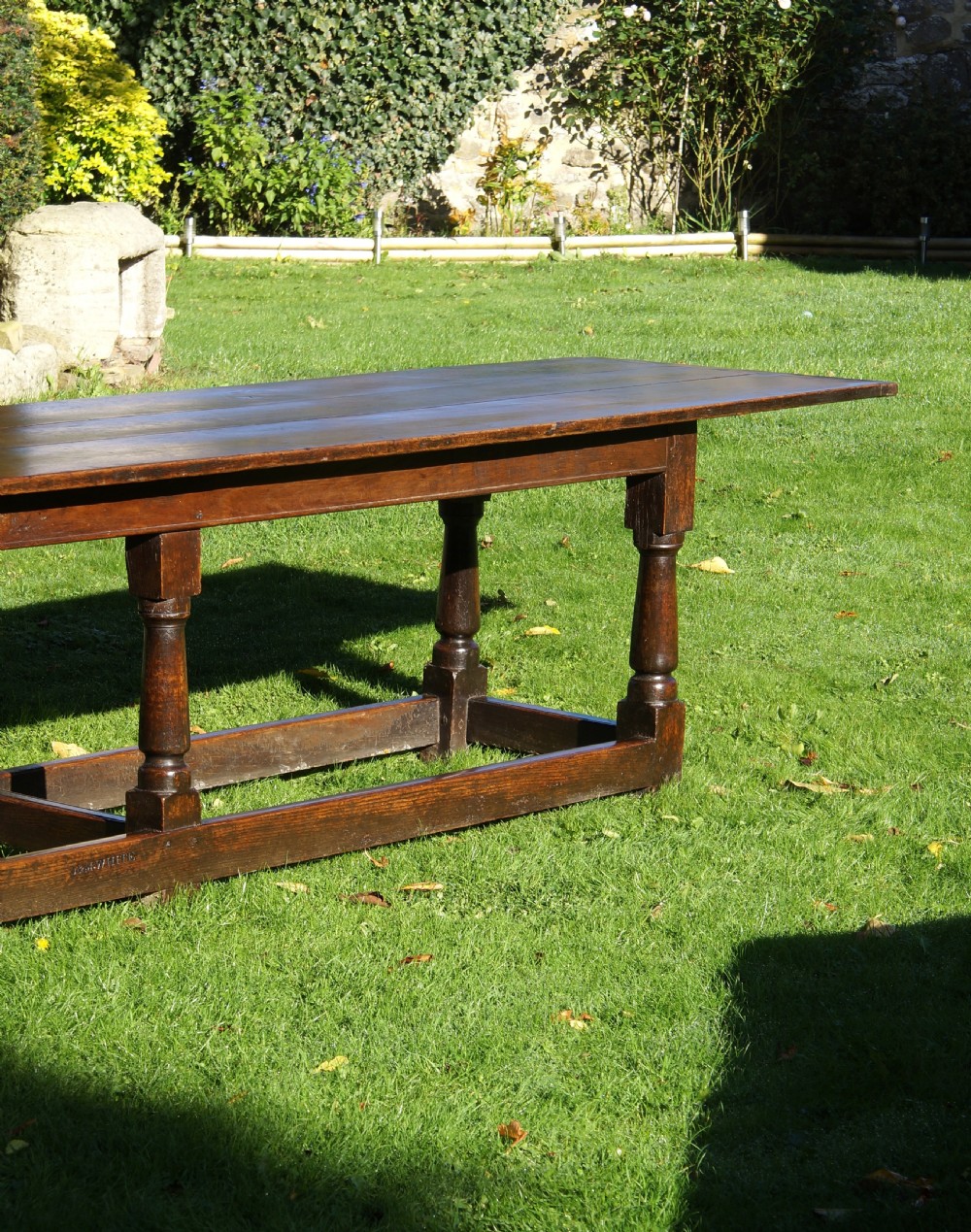 A large 17th-century oak refectory dining table with a long plank top, six turned legs, and robust perimeter stretchers. View V