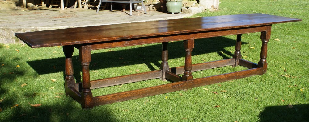 A large 17th-century oak refectory dining table with a long plank top, six turned legs, and robust perimeter stretchers. View VI