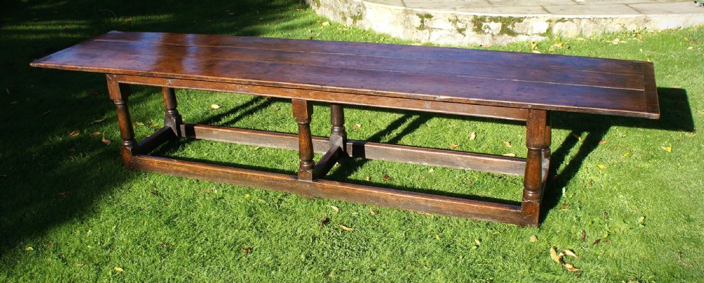 A large 17th-century oak refectory dining table with a long plank top, six turned legs, and robust perimeter stretchers. View VII