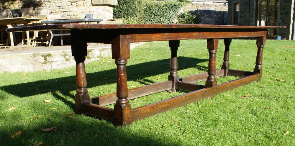 A large 17th-century oak refectory dining table with a long plank top, six turned legs, and robust perimeter stretchers. View VIII