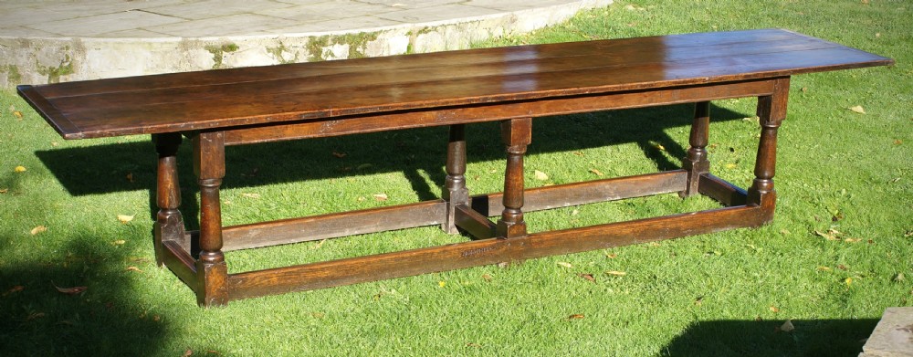 A large 17th-century oak refectory dining table with a long plank top, six turned legs, and robust perimeter stretchers. View XI