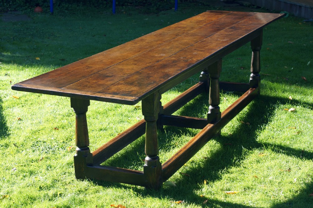 A large 17th-century oak refectory dining table with a long plank top, six turned legs, and robust perimeter stretchers. View XII