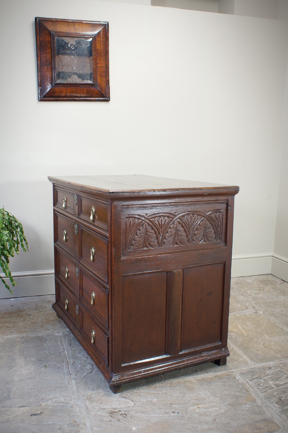 A seventeenth-century dark oak chest of drawers featuring geometric applied mouldings and brass teardrop handles. View III