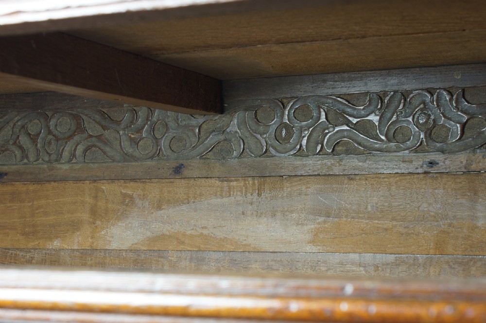 A seventeenth-century dark oak chest of drawers featuring geometric applied mouldings and brass teardrop handles. View XI
