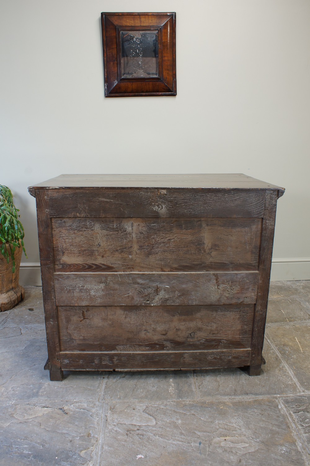 A seventeenth-century dark oak chest of drawers featuring geometric applied mouldings and brass teardrop handles. View XV