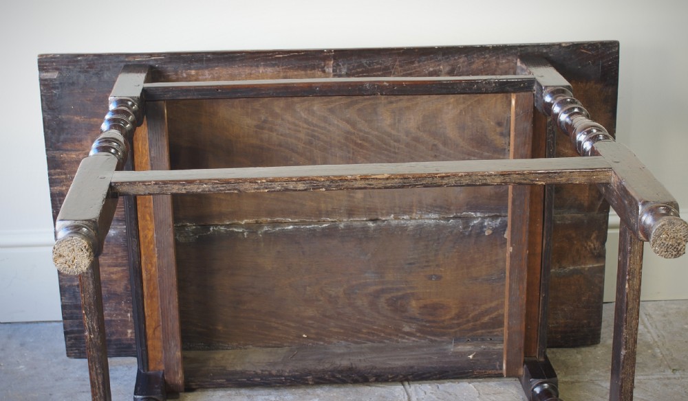 A late 17th-century dark oak side table featuring a single moulded drawer front, brass escutcheon, baluster-turned legs, and a perimeter box stretcher. View VII
