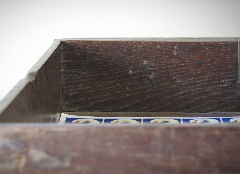 A late 17th-century dark oak side table featuring a single moulded drawer front, brass escutcheon, baluster-turned legs, and a perimeter box stretcher. View VIII