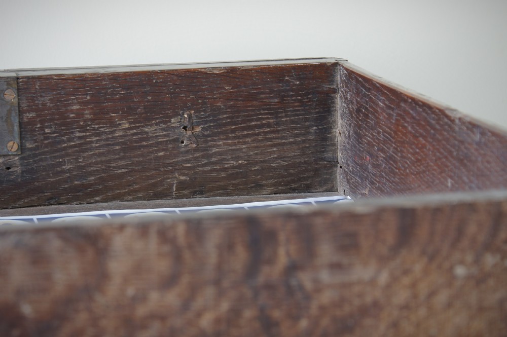 A late 17th-century dark oak side table featuring a single moulded drawer front, brass escutcheon, baluster-turned legs, and a perimeter box stretcher. View IX