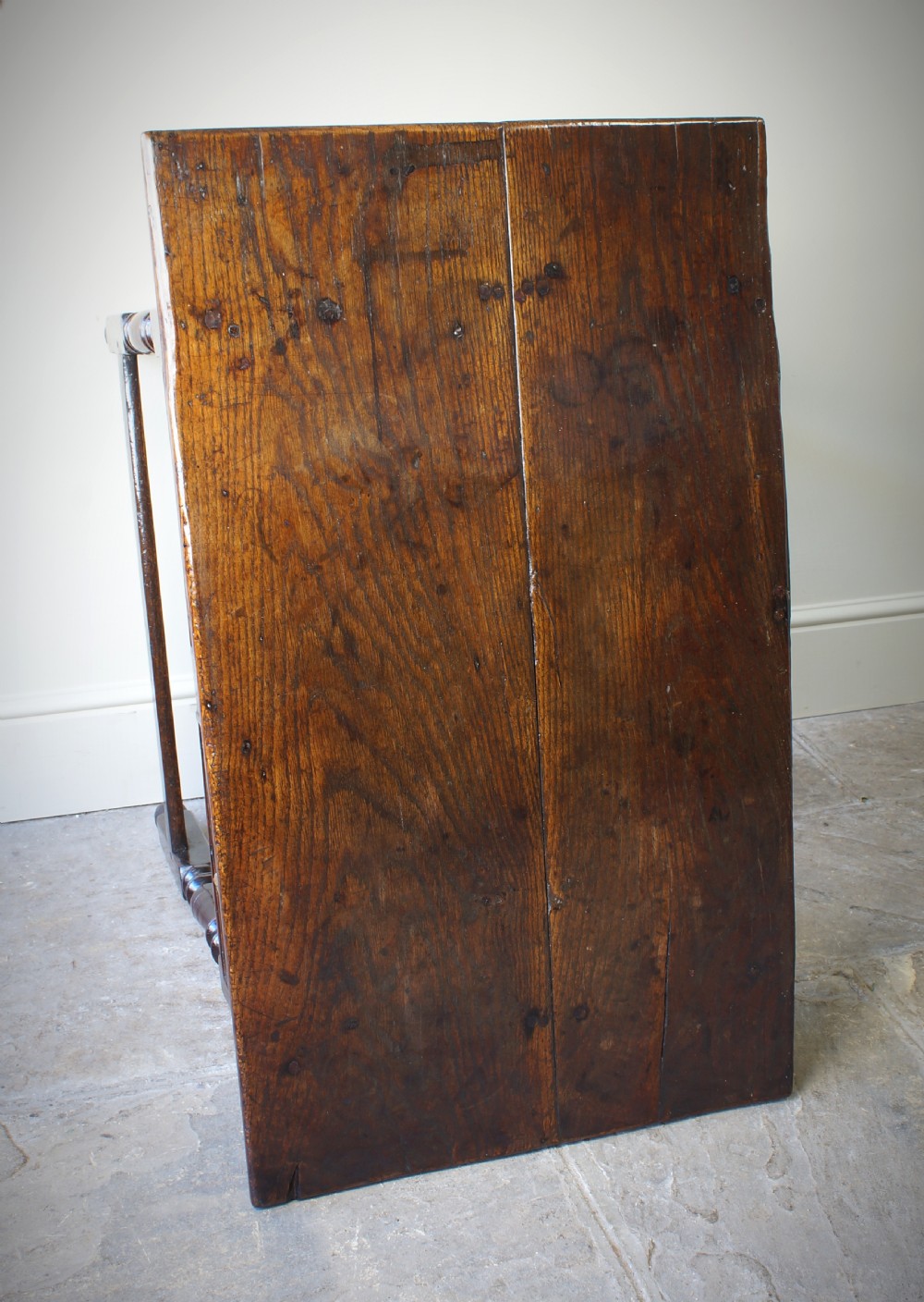 A late 17th-century dark oak side table featuring a single moulded drawer front, brass escutcheon, baluster-turned legs, and a perimeter box stretcher. View XIII