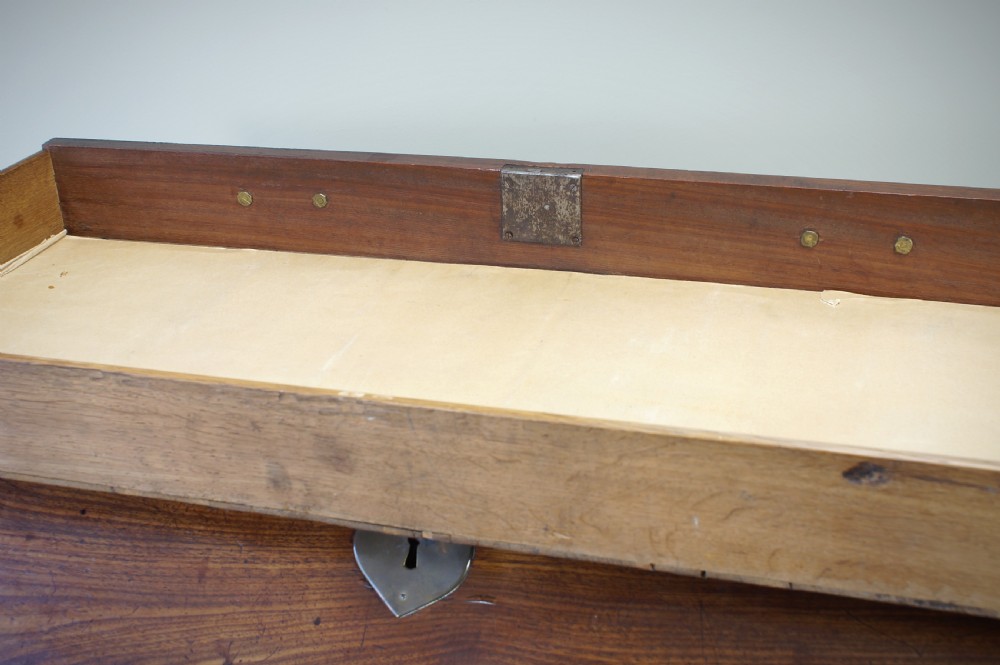 An early Georgian mahogany kneehole bureau featuring a slanted fall-front top lid, brass drop handles, multiple drawers, and a central recessed cupboard on bracket feet. View XV
