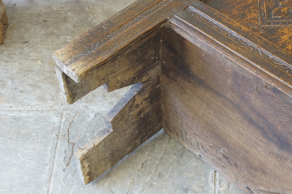 An early 17th-century oak coffer featuring three carved panels with lozenge motifs, an upper carved frieze, and an iron escutcheon. View III
