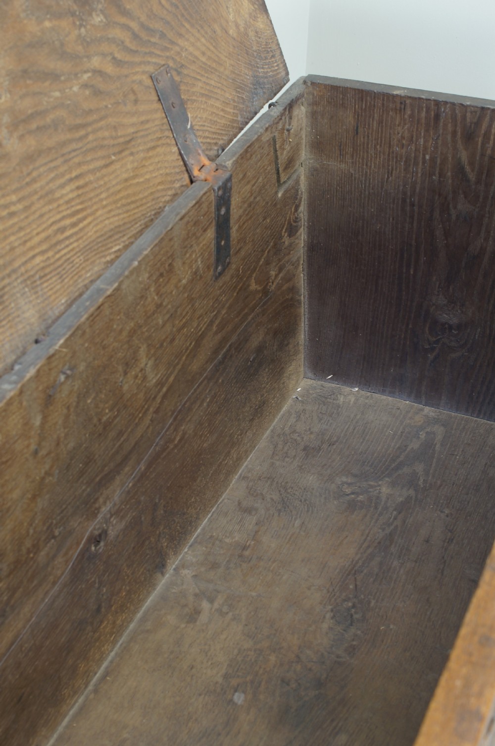 An early 17th-century oak coffer featuring three carved panels with lozenge motifs, an upper carved frieze, and an iron escutcheon. View XII