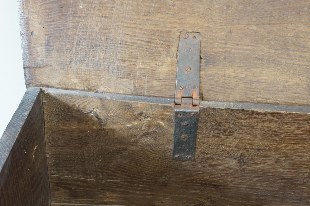 An early 17th-century oak coffer featuring three carved panels with lozenge motifs, an upper carved frieze, and an iron escutcheon. View XIII