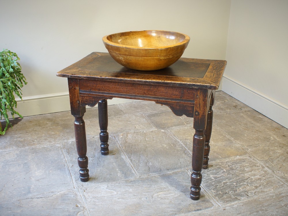 An early 17th century dark oak table with a framed rectangular top, turned legs, and pegged mortise and tenon joinery.